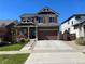 Charming two-story home with landscaped front yard and a concrete driveway on a sunny day at 4995 S Algonquian Way, Aurora, CO 80016