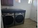Modern laundry room with front load washer and dryer and a dark countertop at 4995 S Algonquian Way, Aurora, CO 80016