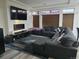 Comfortable living room with a gray sectional sofa, sleek entertainment center and a large television at 4995 S Algonquian Way, Aurora, CO 80016