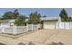 Charming single-story home featuring a well-maintained front yard, a garage, and a classic white picket fence at 1101 Dakin St, Denver, CO 80221
