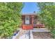 Inviting front porch with brick facade, red stairs, wood railings, and manicured greenery enhancing the curb appeal at 1101 Dakin St, Denver, CO 80221