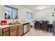Functional kitchen featuring stainless steel dishwasher, sink, and view of a dining area at 1101 Dakin St, Denver, CO 80221