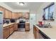 Functional kitchen with oak cabinets, stainless steel appliances, and a view of a dining area at 1101 Dakin St, Denver, CO 80221