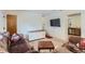 Cozy living room featuring a brown sofa, mounted TV, and view of the adjacent kitchen at 1101 Dakin St, Denver, CO 80221