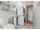 Charming bathroom featuring a pedestal sink, stacked washer/dryer and hardwood flooring at 33 N Corona St # 404, Denver, CO 80218