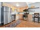 Well lit kitchen with stainless steel appliances, wooden cabinetry, hard wood floors and stylish rug at 33 N Corona St # 404, Denver, CO 80218