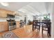 Bright kitchen flowing into a dining and living area featuring a stainless steel oven and light wooden cabinets at 33 N Corona St # 404, Denver, CO 80218