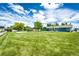 Expansive backyard with lush green grass, mature trees, and a spacious lawn area at 1853 Burton St, Strasburg, CO 80136