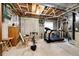 Unfinished basement with concrete walls and ceiling and exercise equipment and storage space at 1853 Burton St, Strasburg, CO 80136