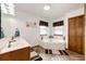 Bright bathroom with double sink vanity, a corner soaking tub, and modern wood-look flooring at 1853 Burton St, Strasburg, CO 80136