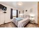This cozy bedroom features a comfortable queen-sized bed, soft lighting, and a charming window view at 1853 Burton St, Strasburg, CO 80136