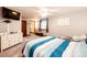 This is a bedroom featuring a large bed and a wooden dresser, offering a comfortable and well-equipped space at 1853 Burton St, Strasburg, CO 80136