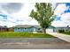 Charming blue ranch home featuring a well-manicured lawn and inviting curb appeal at 1853 Burton St, Strasburg, CO 80136