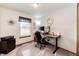 This home office features a modern wood desk, comfortable chair, and ample natural light for a productive workspace at 1853 Burton St, Strasburg, CO 80136