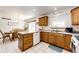 Traditional-style kitchen with wooden cabinets, white appliances, and a dining area with a wooden table at 1853 Burton St, Strasburg, CO 80136