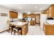 Well-lit kitchen with wood cabinets, white countertops and appliances, and breakfast bar seating at 1853 Burton St, Strasburg, CO 80136