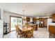 A combined kitchen and dining area featuring wood cabinets, white tile floors, and a sliding door to the outside at 1853 Burton St, Strasburg, CO 80136