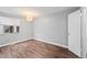 Neutral bedroom with hardwood flooring, a window, and a white door at 17004 E Tennessee Dr # 103, Aurora, CO 80017
