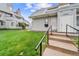 A well-maintained townhome showing the entrance, gray siding, and lush green lawn at 17004 E Tennessee Dr # 103, Aurora, CO 80017