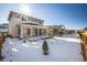 Snow-covered backyard with a sunroom and a covered patio at 21837 E Stanford Cir, Aurora, CO 80015
