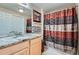 Bathroom features a single sink vanity, tiled floors, and a shower with decorative curtain at 22560 E Ontario Dr # 204, Aurora, CO 80016