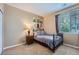 Bedroom with a metal frame bed, end table, lamp, abstract art, and window with blinds at 22560 E Ontario Dr # 204, Aurora, CO 80016