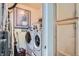 Functional laundry room with a front-loading washer and dryer set, storage cabinets, and modern decor at 22560 E Ontario Dr # 204, Aurora, CO 80016
