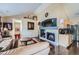 Stylish living room with a fireplace, mounted TV, and hardwood floors open to the kitchen at 22560 E Ontario Dr # 204, Aurora, CO 80016
