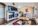 Inviting living room showcasing a fireplace, TV, comfortable couch, and adjacent kitchen area at 22560 E Ontario Dr # 204, Aurora, CO 80016