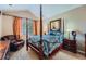 Bedroom with a four-poster bed, sitting chair, window, and an abstract patterned comforter at 22560 E Ontario Dr # 204, Aurora, CO 80016
