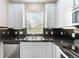 Well-lit kitchen featuring white cabinets, black countertops, stainless steel appliances and a window view at 3760 Ute Mountain Trl, Castle Rock, CO 80109