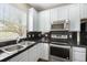 Well-lit kitchen features stainless steel appliances, black countertops, and white cabinets at 3760 Ute Mountain Trl, Castle Rock, CO 80109