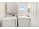 Bright laundry room features a washer, dryer, cabinets, and an exterior window at 3760 Ute Mountain Trl, Castle Rock, CO 80109