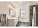 Bright bathroom featuring dual sink vanity and a stone-tiled walk-in shower at 5155 E 108Th Pl, Thornton, CO 80233