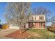 Charming two-story home featuring red shutters, brick accents, a well-maintained lawn, and mature trees at 5155 E 108Th Pl, Thornton, CO 80233