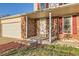 Inviting covered front porch with brick facade, white columns, and a well-manicured lawn at 5155 E 108Th Pl, Thornton, CO 80233