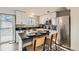 Modern kitchen featuring stainless steel appliances, white cabinets, and a center island with seating at 5155 E 108Th Pl, Thornton, CO 80233