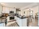 Bright kitchen with stainless steel appliances, white cabinets, island seating, and adjacent dining area at 5155 E 108Th Pl, Thornton, CO 80233