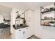 This kitchen features white cabinets, floating shelves, and black marble countertops at 5155 E 108Th Pl, Thornton, CO 80233