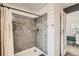 Updated bathroom showcasing a pebble-accented tile shower and modern finishes at 5155 E 108Th Pl, Thornton, CO 80233