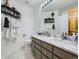 Bathroom features a double sink vanity, a large mirror, and convenient shelving for storage at 6366 Umber Cir, Arvada, CO 80403