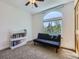 Bedroom features a large window, a ceiling fan, and a futon couch at 6366 Umber Cir, Arvada, CO 80403
