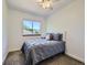 Cozy bedroom with a gray bed, soft natural light, and view of the surrounding landscape at 6366 Umber Cir, Arvada, CO 80403