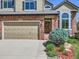 Close-up showcasing the brick exterior, garage door, and landscaped entry of the charming two-story home at 6366 Umber Cir, Arvada, CO 80403