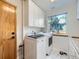 Bright laundry room features a side-by-side washer and dryer with overhead cabinets at 6366 Umber Cir, Arvada, CO 80403