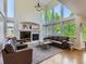 Inviting living room boasts soaring ceilings, a fireplace, and large windows offering views of the lush greenery outside at 6366 Umber Cir, Arvada, CO 80403