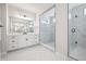Bright bathroom with white cabinets, double vanity, tile flooring, and a glass shower at 4949 Hickory Oaks St, Castle Rock, CO 80104