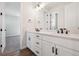 A bathroom featuring a double vanity with black hardware, wood-style flooring, and neutral walls at 4949 Hickory Oaks St, Castle Rock, CO 80104