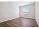 An empty bedroom with wood-style flooring, white walls, and a large window offering natural light at 4949 Hickory Oaks St, Castle Rock, CO 80104