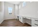 A bright home office featuring custom built-in desks with countertops and wood-style flooring at 4949 Hickory Oaks St, Castle Rock, CO 80104